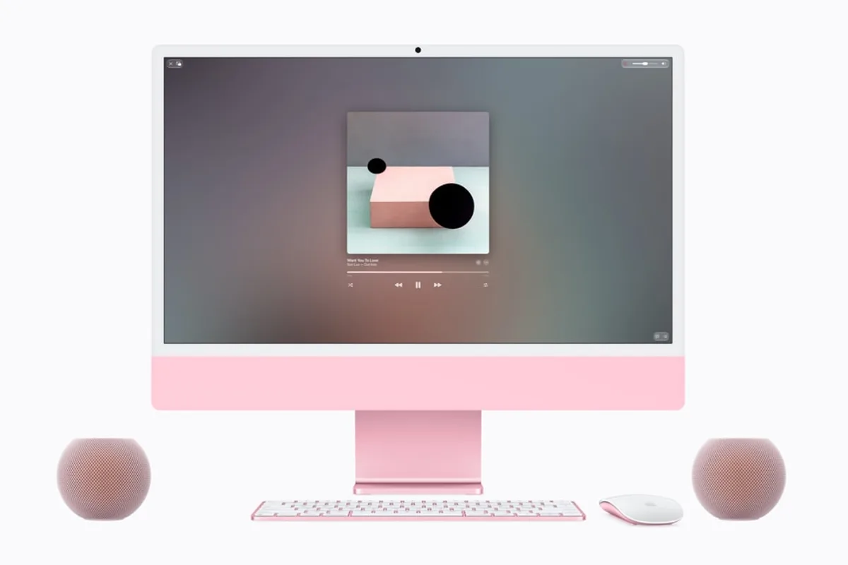 Deux HomePod mini 2 roses installés de chaque côté d'un iMac de couleur assortie